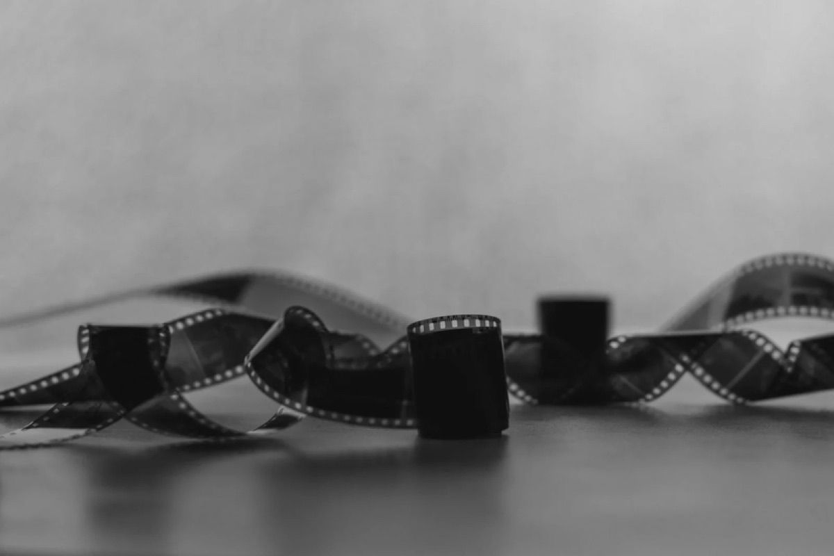 Tira de película de 35 mm enrollada sobre una mesa, en blanco y negro