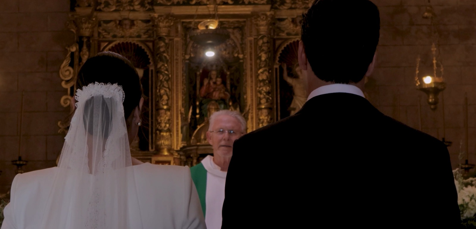 Ceremonia de boda en una iglesia: los novios de espaldas ante el altar