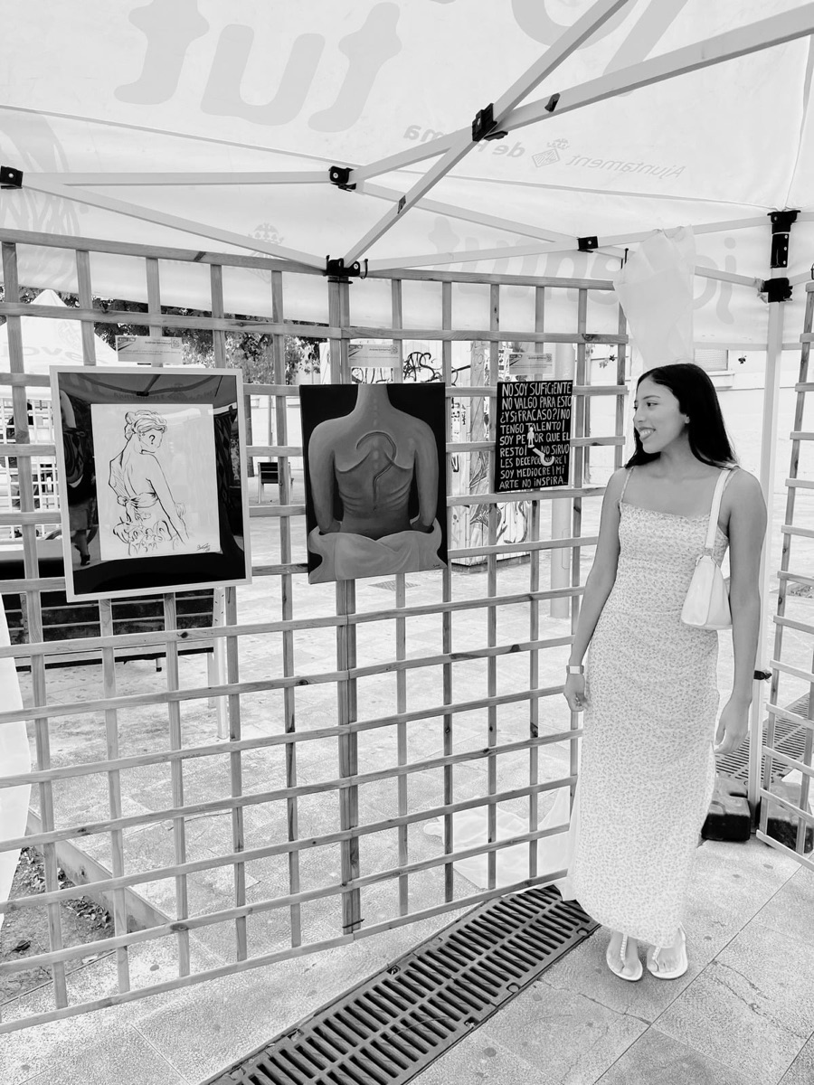 Andrea junto a su obra en una exposición al aire libre