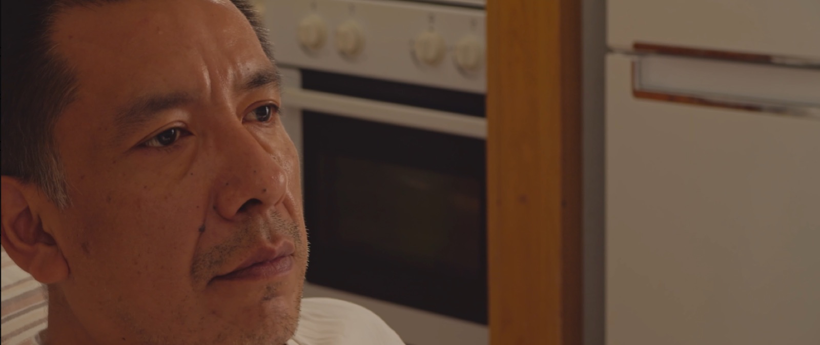Fotograma de Fragmentos de Willy: un hombre mira por la ventana de su cocina